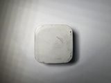 a small white object on the wall with a red marker