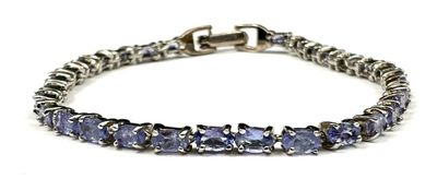 a silver bracelet with tan sapphire stones on a white background