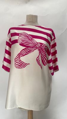 pink and white striped shirt with a bow on a mannequin