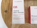 two boxes of clarins sitting on a wooden tray
