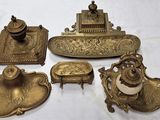 plusieurs objets anciens en laiton posés sur une nappe blanche