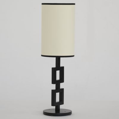 une lampe de table noire surmontée d'un abat-jour blanc
