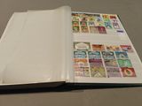 an open book with stamps on it sitting on a table