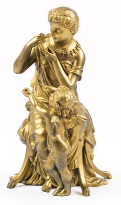 une statue antique en bronze représentant une femme avec un enfant et un chien