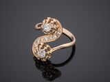 a gold ring with two diamonds on a black surface