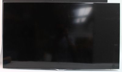 une télévision à écran plat posée sur une table devant une fenêtre