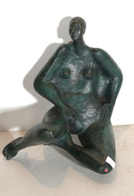 statue of a man sitting on the ground with his legs crossed