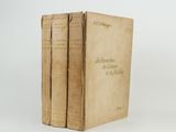 two old books sitting on top of each other on a white surface