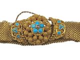 un gros plan d'une ceinture dorée ornée de pierres bleues