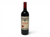 une bouteille de vin rouge posée sur une table blanche