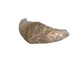 une chaussure en bronze posée sur une surface blanche