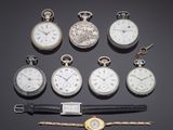 several different types of pocket watches are displayed on a black surface