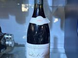 a bottle of wine sitting on a counter in a glass case