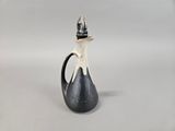 a black and white vase with a cat sitting on top of it