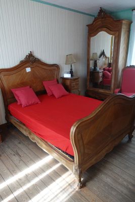 un lit avec des draps et des oreillers rouges dans une chambre