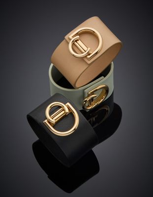 trois bracelets en cuir de couleurs différentes, dotés d'une boucle dorée