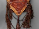 an old leather purse with fringes hanging on a wall