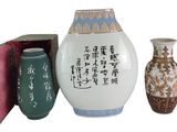 trois vases posés l'un à côté de l'autre sur une surface blanche