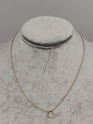 a gold necklace with a crescent charm on a mannequin neck