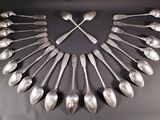 a clock made out of spoons and forks on a table