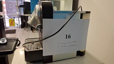 a coffee machine with a sign on it sitting on a counter