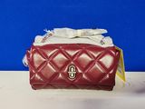 red quilted purse with a bow on top of it on a table