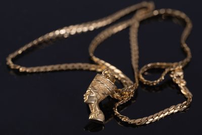 un collier en or orné d'une tête humaine