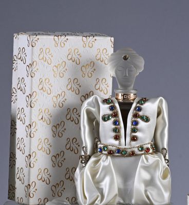a figurine of a woman in a white dress and a box