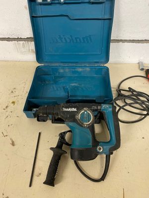 une image représentant une boîte à outils bleue contenant un marteau et une perceuse