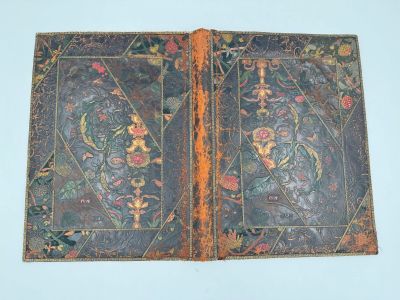 un vieux livre sur lequel figure l'image d'un oiseau et de fleurs