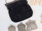 a black purse and some gloves on a white table