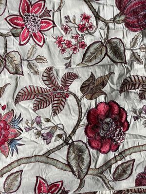a close up of a quilt with flowers and leaves on it