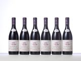 six bottles of wine are lined up on a table