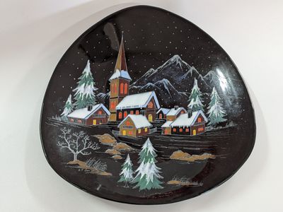 a plate with a picture of a church and trees on it