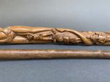 a wooden stick with a carving of a man laying on it