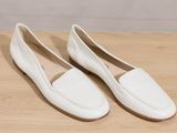 a pair of white shoes on a wooden table