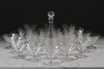 de nombreux verres à vin et une carafe posés sur une table