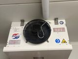 a fan sitting on top of a box in a room
