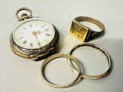 two rings and a watch sitting next to each other on a table