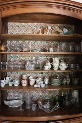 un meuble en bois contenant beaucoup de vaisselle et de tasses