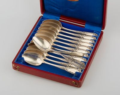 six silver spoons in a red case on a white surface
