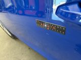 a close up of a blue car with a sticker on it