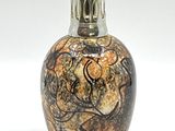 un petit vase orné d'un motif, posé sur une table