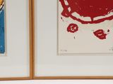 two paintings on the wall of a room one is red and the other is blue