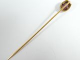 a close up of a gold stick with a purple stone on it