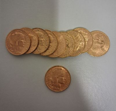 un gros plan sur un tas de pièces d'or à côté d'un penny
