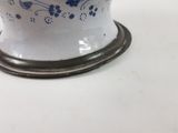 a blue and white vase on a stand on a table