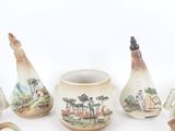 five pieces of pottery that are sitting on a white surface