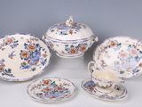 four pieces of china on a table with a cup and saucer