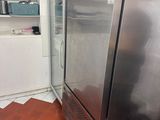 a stainless steel refrigerator in the corner of a kitchen